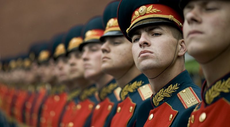 men in black and red cade hats and military uniform