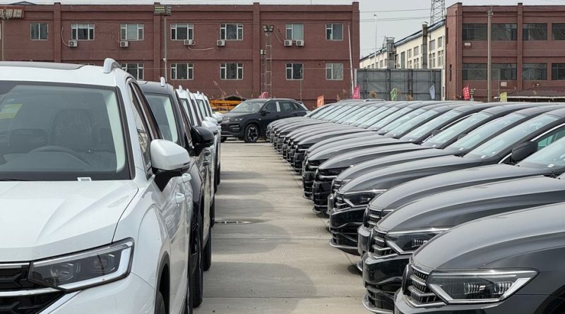 row of new cars in industrial parking lot